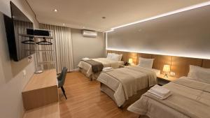 a hotel room with two beds and a television at Di Garda Hotel in Encarnación