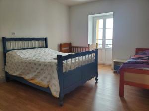 a bedroom with a blue bed and a window at Gite Bains jolivet in Bains