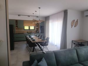a dining room and kitchen with a table and a couch at Paradiso Beach House in Lopar