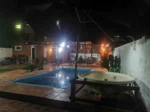 a bath tub sitting next to a pool at night at Hostel Ysapy en Piribebuy - Paraguay in Piribebuy