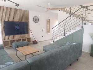 a living room with a couch and a tv at Paradiso Beach House in Lopar