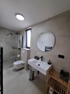 a bathroom with a sink and a toilet and a mirror at Paradiso Beach House in Lopar +22 photos