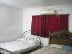 a room with two beds and a red curtain at Reina Elizabeth I in Santa Marta