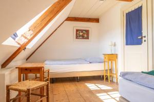 a bedroom with a bed and a table in a attic at Ferienwohnung Schulkate I - Boldevitzer Rügenkaten in Parchtitz