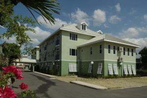 a large green building with white shuttered windows at Choose To Be Happy at EI8HT - Super Studios and 1-BR Penthouse Apartment in Kingston
