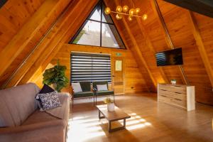 an attic living room with a couch and a tv at GRETEL CHALETS SUIZO in Guatapé