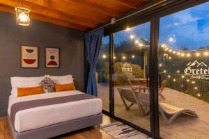 a bedroom with a bed and a patio with lights at GRETEL CHALETS SUIZO in Guatapé