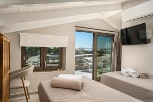 a bedroom with two beds and a balcony at Alpha Waves By Banana Beach in Vasilikos +30 photos