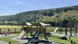 a park with a playground with a slide and swings at Dale House in Kettlewell