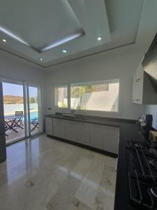 a large kitchen with a view of a pool at Villa mnar 3 chambre en haut in Tangier