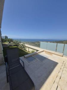 a chair on a patio with a view of the ocean at Villa mnar 3 chambre en haut in Tangier