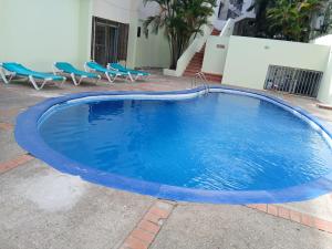 a large swimming pool with blue chairs around it at 4 Bedroom 4 Bath & Laundry Room Apartment in Sosúa