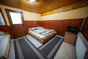 a small bedroom with a bed and a television at Комплекс Петлето in Sokolovtsi