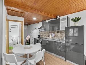 a kitchen with a white table and white chairs at Casa da Moleira in Amares