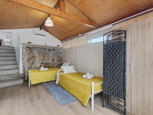 a bedroom with a yellow bed and a stone wall at Casa da Moleira in Amares