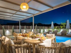 a patio with a table and chairs and a pool at Alpha Waves By Banana Beach in Vasilikos