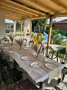 a long table with white plates on top of it at Guest house Villa Orlovo in Orlovo