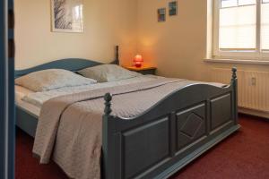 a bedroom with a large bed with a blue frame at Ferienwohnung Hoffmann in Hooksiel