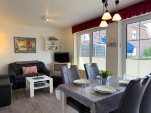 a living room with a table and chairs and a couch at Ferienwohnung Hoffmann in Hooksiel