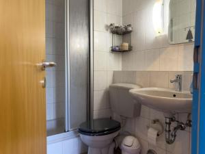 a bathroom with a toilet and a sink at Ferienwohnung Hoffmann in Hooksiel +12 photos