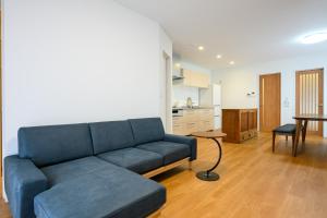 una sala de estar con un sofá azul y una mesa en KOAのお宿 ー Koa no Oyado ー, en Gujō
