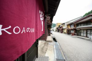 un edificio con una pancarta morada en el lateral de una calle en KOAのお宿 ー Koa no Oyado ー, en Gujō