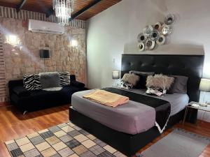 a bedroom with a large bed and a couch at Villa Toscana in Maturín