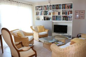 a living room with wicker chairs and a tv at La Bastide des Marcassins in Moissac-Bellevue