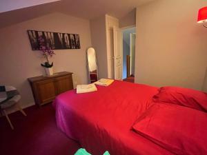 a bedroom with a red bed and a mirror at Valentine in Monflanquin