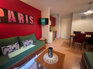 a living room with a green couch and a red wall at Valentine in Monflanquin