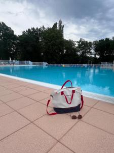 a white bag sitting on the ground near a swimming pool at Valentine in Monflanquin +13 photos