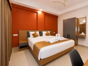 a bedroom with a bed with a flower on it at Nova Alhind Airport Hotel Cochin in Nedumbassery