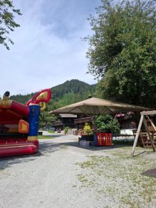 a park with a playground with a slide and an umbrella at Appartements Baumanngut in Wagrain
