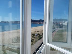 uma janela aberta com vista para a praia em Hotel Playa em Cangas