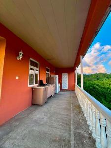 an orange house with a balcony with a kitchen and a window at Mamuka's Villa in Tsqaltsminda +8 photos