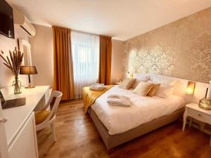a bedroom with a large bed and a desk and a window at Le Royal Picardie, BW Signature Collection in Albert