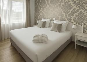 a large white bed in a room with a window at Le Royal Picardie, BW Signature Collection in Albert