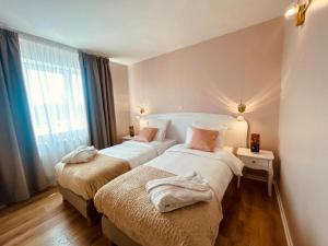 a hotel room with two beds and a window at Le Royal Picardie, BW Signature Collection in Albert +39 photos