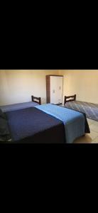 a bedroom with two beds with blue sheets at Chácara com piscina no condomínio Vitassay in Boituva +26 photos