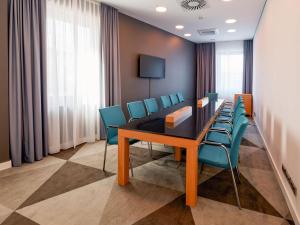 a conference room with a wooden table and blue chairs at Premier Inn Mannheim City Centre in Mannheim