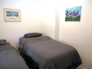 a bedroom with two beds and a painting on the wall at Renovated 6 Bedroom Chalet Hot Tub Near Village in Blue Mountains