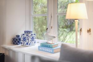 a table with books and a lamp and a window at Seepferdchen in Keitum
