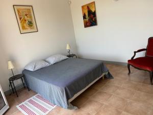 a bedroom with a bed and a red chair at Orangerie in Benais
