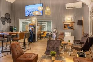 a room with chairs and a table and a tv on the wall at Sure Hotel by Best Western Angers Sud in Les Ponts-de-Cé