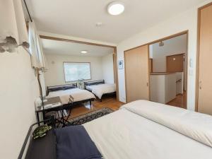 a hotel room with two beds and a kitchen at Frog Inn - Entire House for Private Use in Fujinomiya