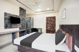 a bedroom with a bed and a tv on a wall at Hotel O SWEDHA HOTEL in Hazārībāg