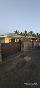 a house with a wooden fence and a driveway at Superbe Suite parentale Chez l'habitant avec SPA et petit déjeuner in Saint-Pierre