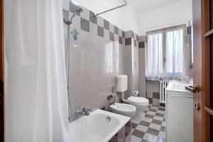 a white bathroom with a toilet and a sink at Appartamento Isabella in Verbania