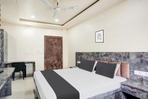 a bedroom with a bed and a desk at Hotel O SWEDHA HOTEL in Hazārībāg +23 photos