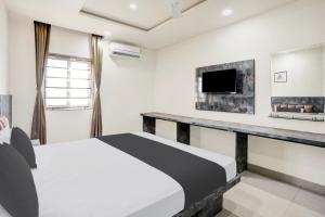 a bedroom with a bed and a table with a tv at Hotel O SWEDHA HOTEL in Hazārībāg